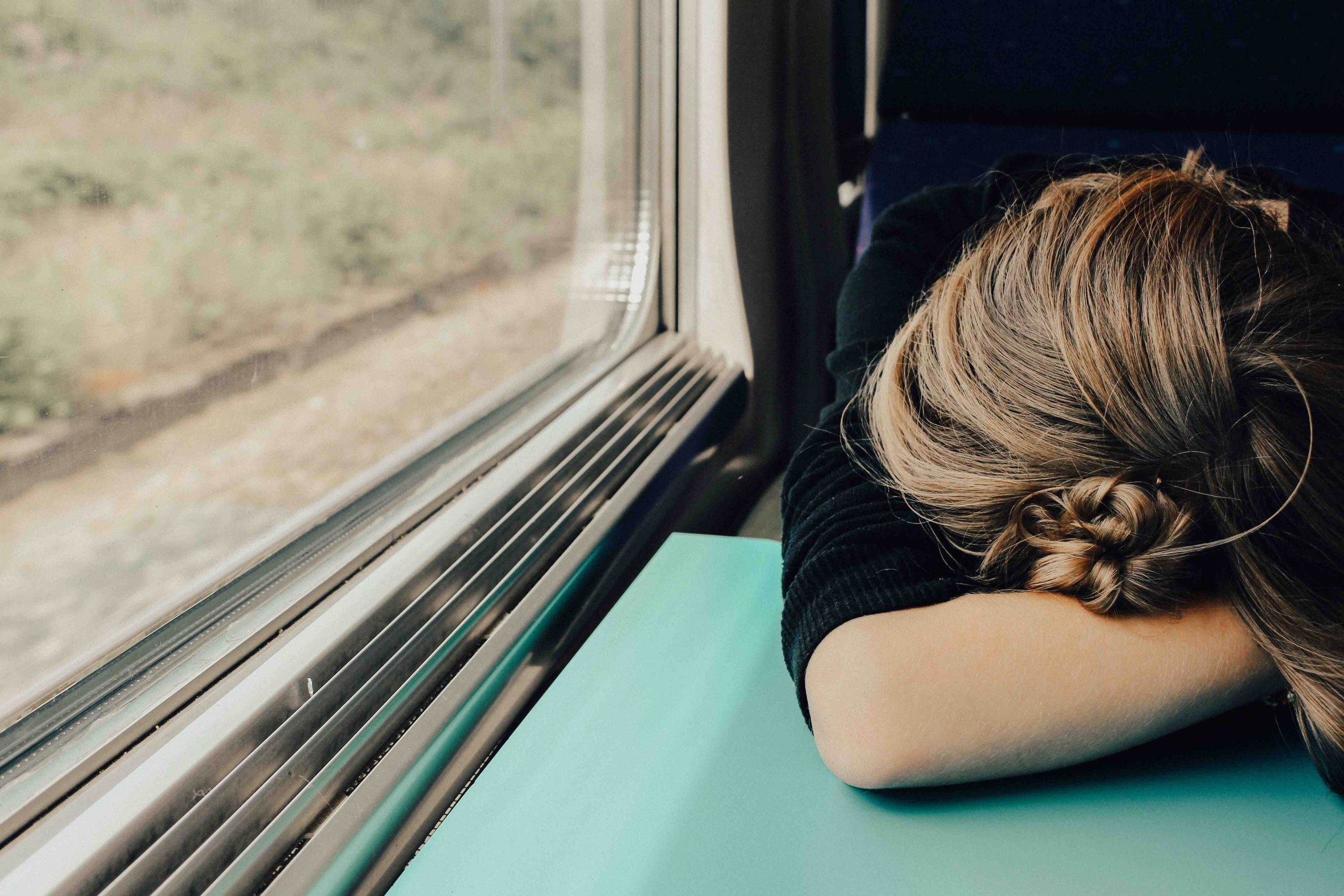A woman with her head down in her arms on a table