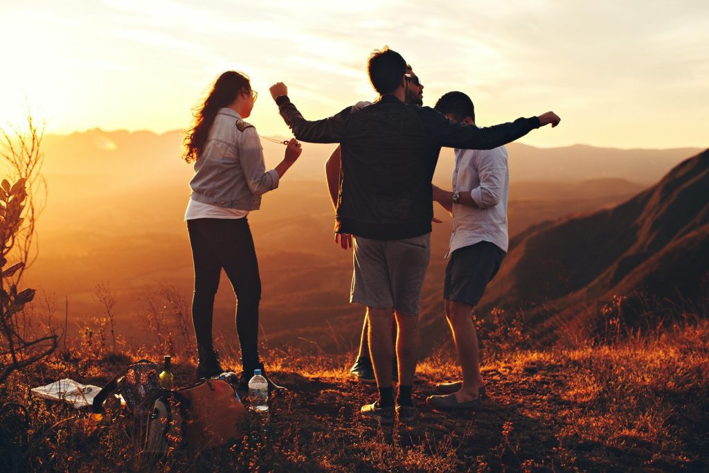 four people standing on edge of mountain with outcomes from counselling