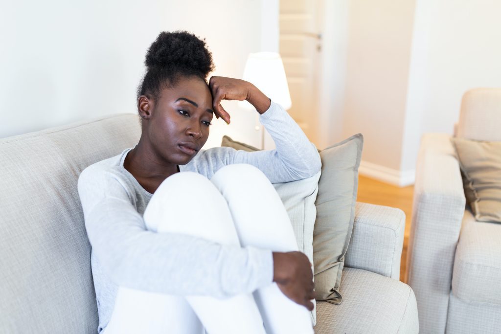 Sad woman on couch looking aimlessly