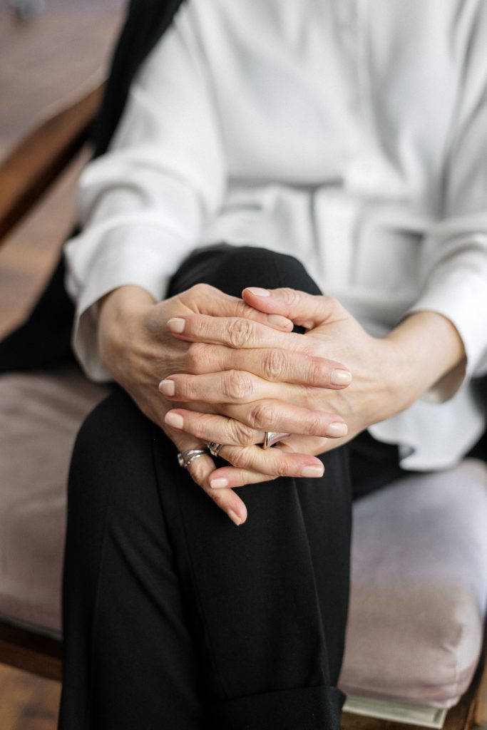 Clasped hands of a woman who is sitting