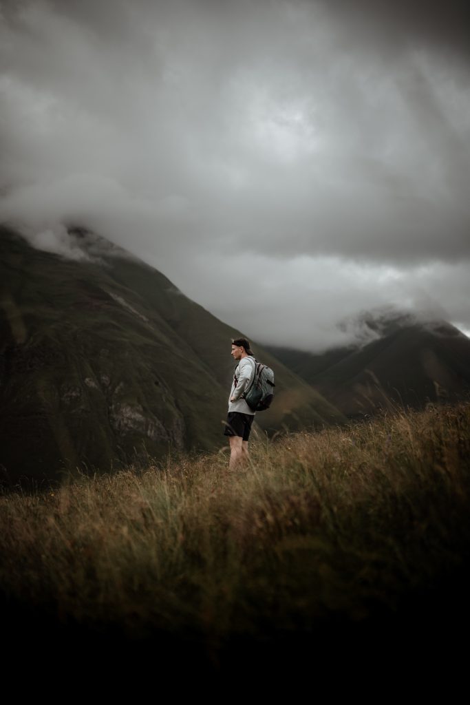 Man pausing while on a cloudy hike