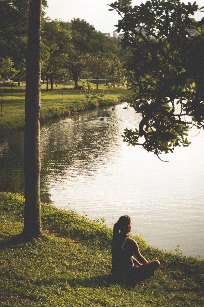 Woman meditating at a pond