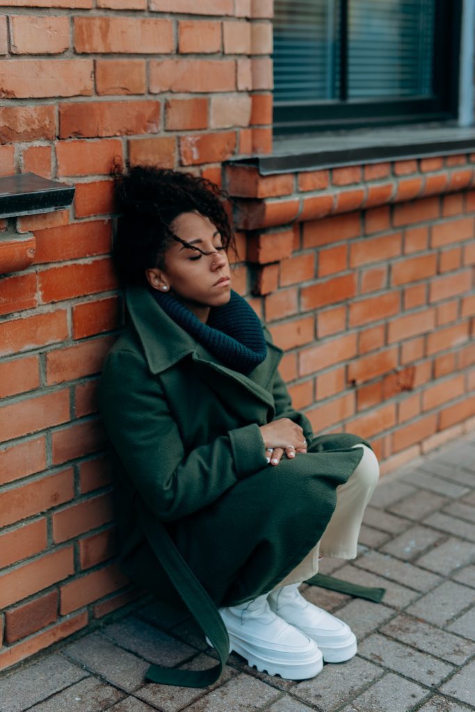 Young woman crouched down on a sidewalk