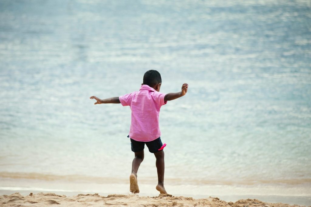 Young boy on a beach running towards the water