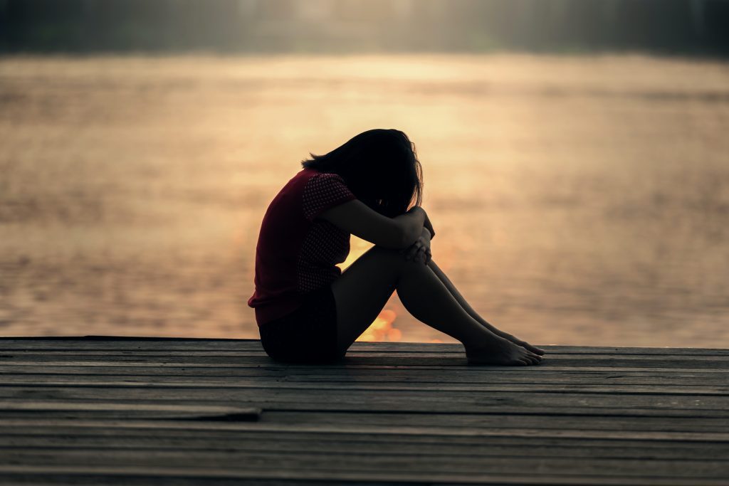 Woman with her head down on a dock