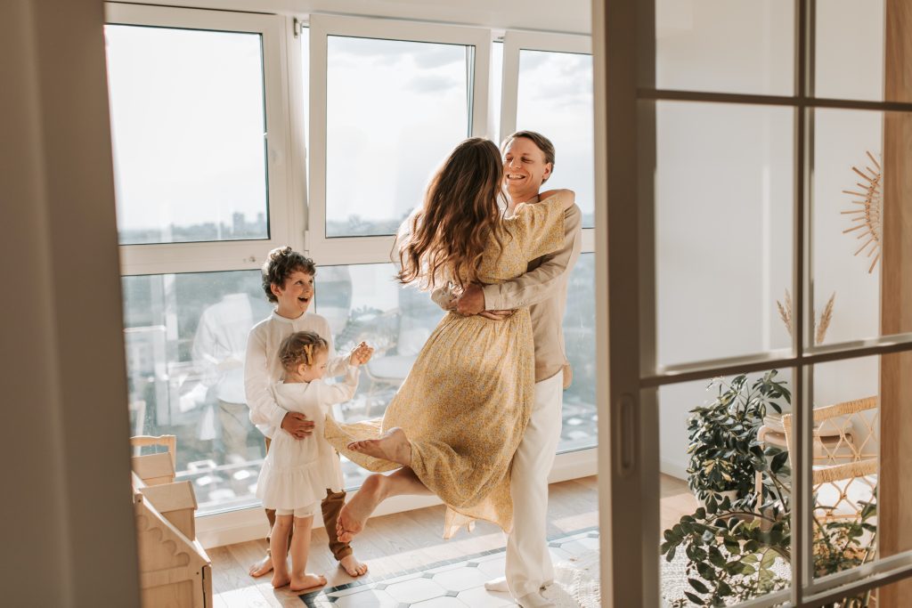 Happy couple with young children looking on