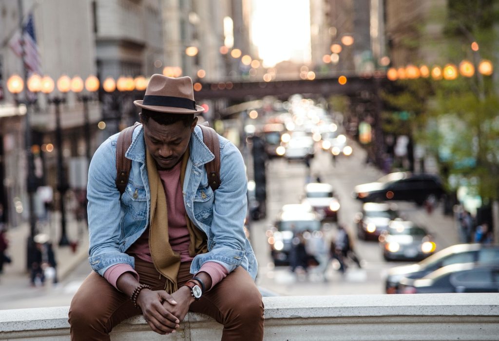 Young man sitting down looking downcast